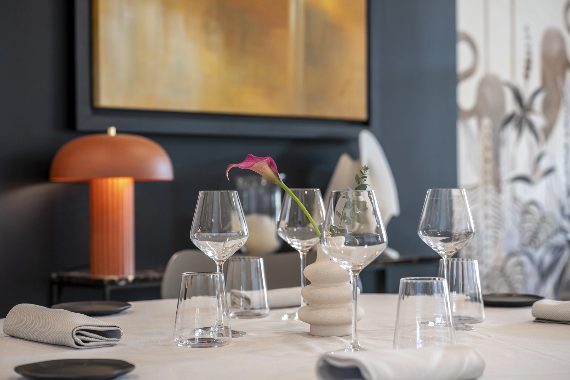 Table dressée dans l'alcôve à mur ardoise de l'Auberge d'Arthaz, lampe champignon terracotta et tableaux muraux