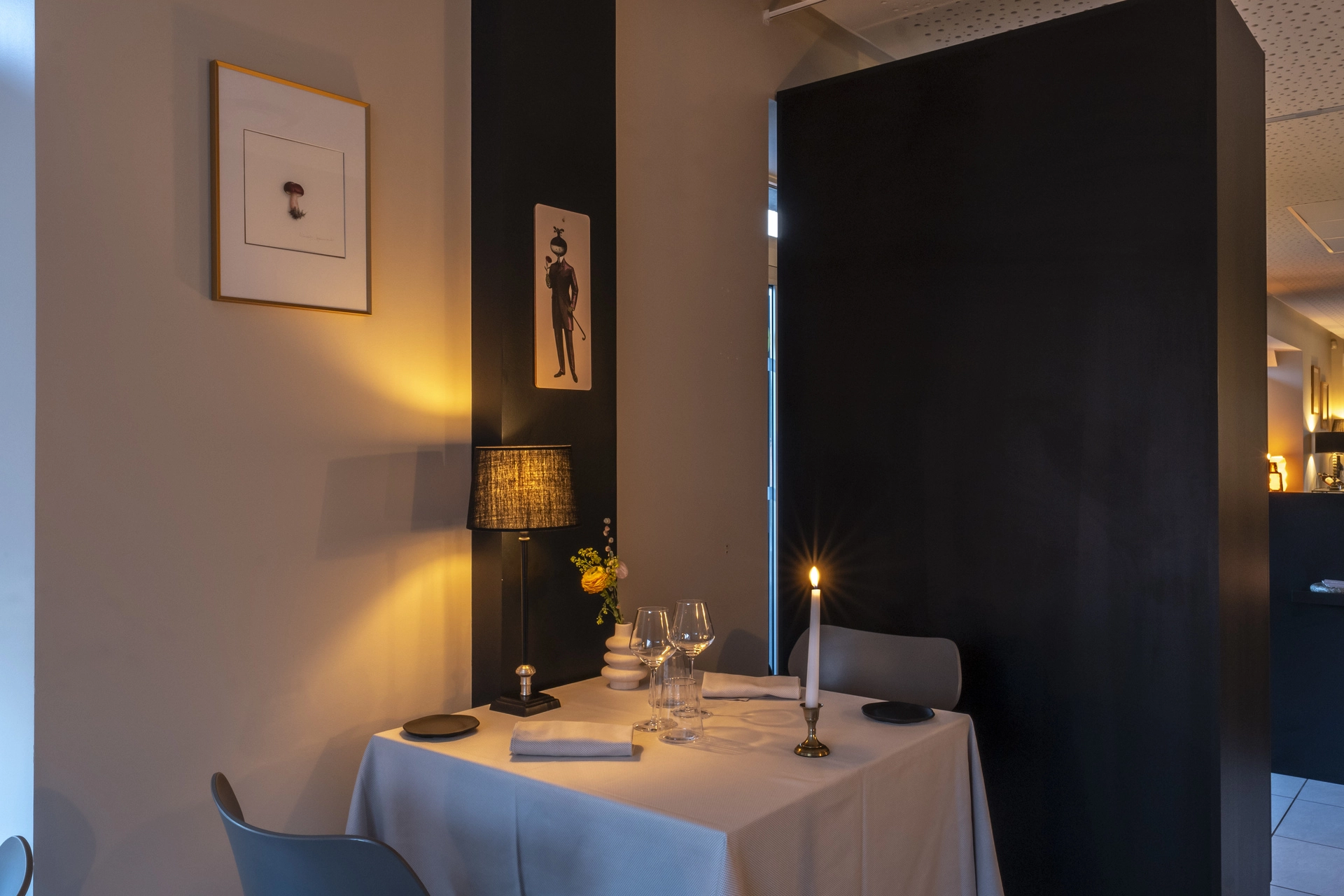 Petite table en alcôve avec bougie et lampe noire, illustration vintage sur cloison sombre, Auberge d'Arthaz